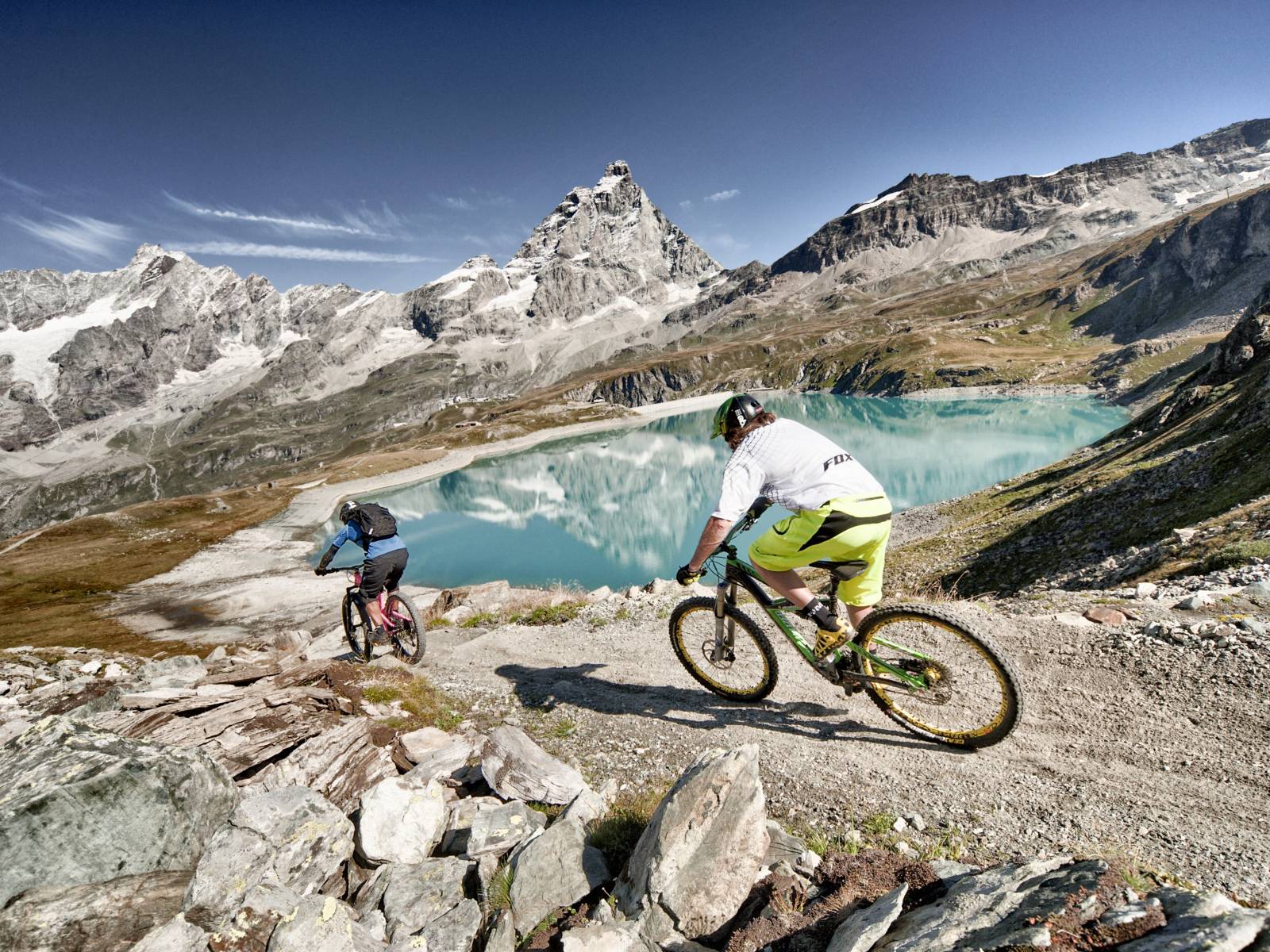 Mountain biker lungo un sentiero panoramico a Cervinia, tra laghi alpini, paesaggi d'alta quota e spettacolari viste sul Monte Cervino.